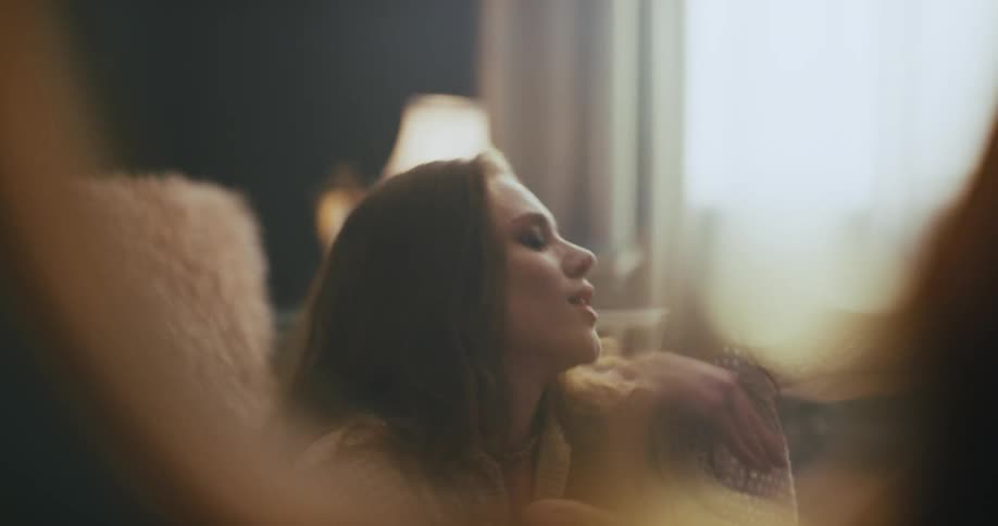 A woman sitting on the floor of her living room while dancing and enjoying the music