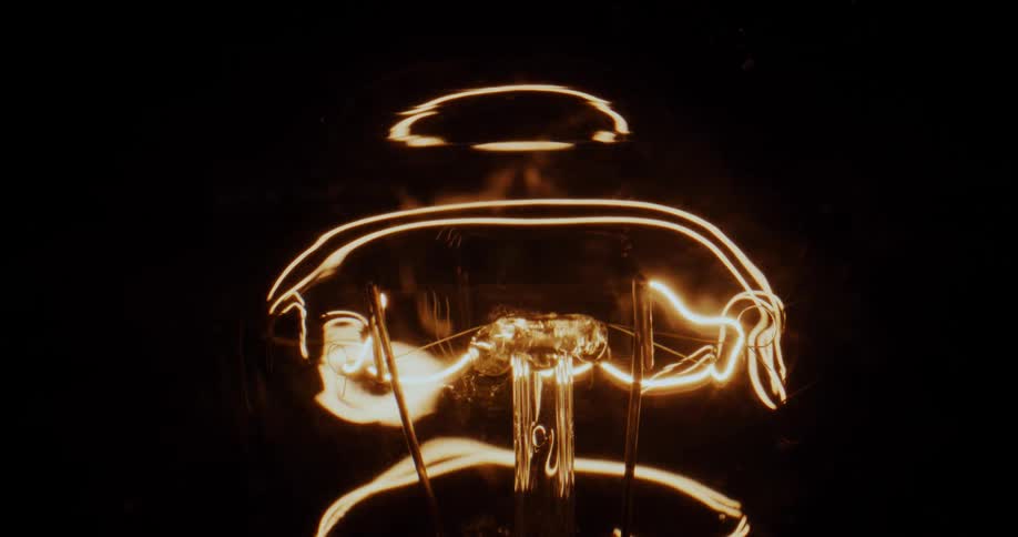 Neon amber light glows in the darkness as it moves as if it is alive