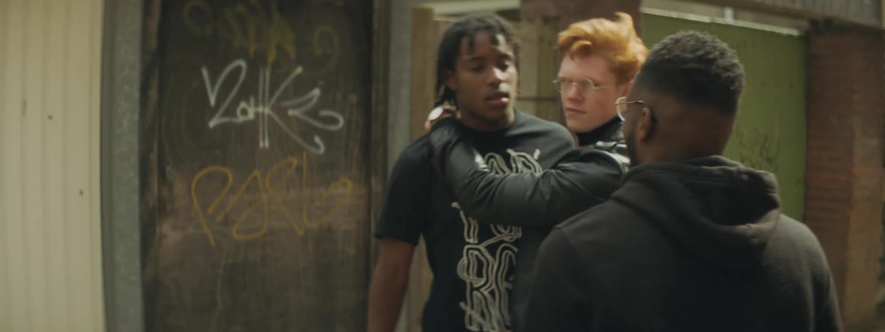 Two men push and fight each other while another man steps in to stop them