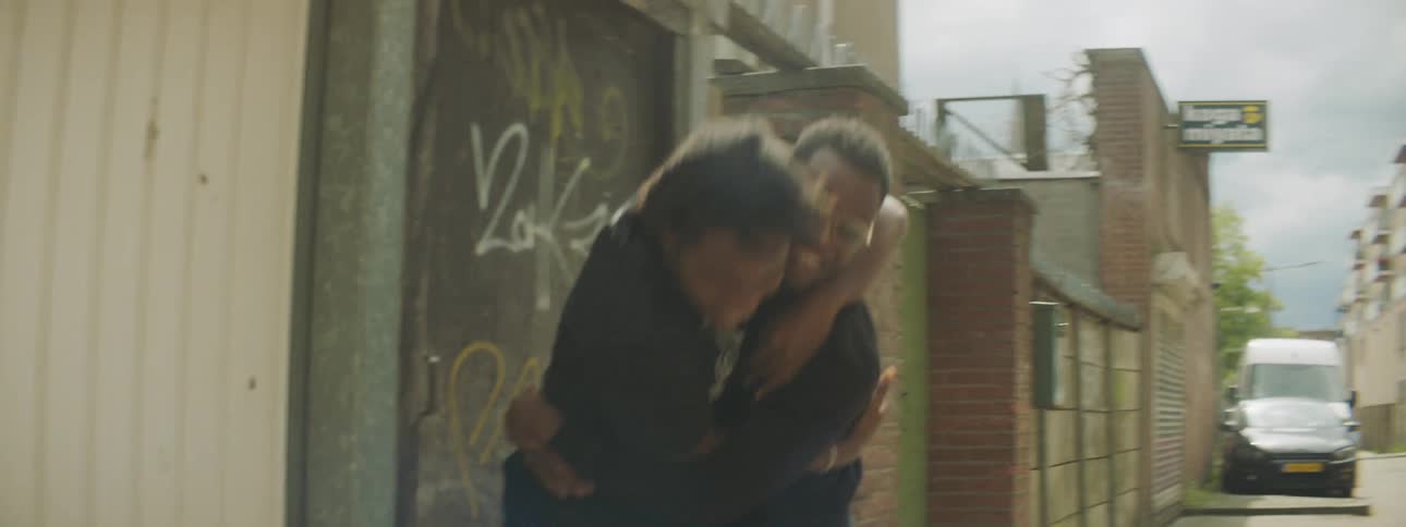 Friends happily greeting each other in a back alleyway
