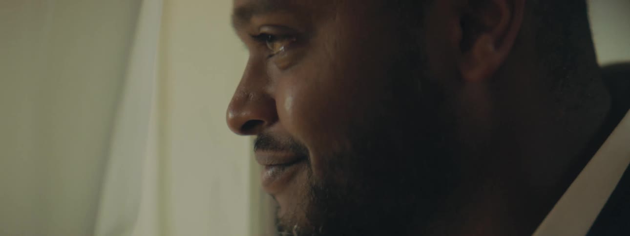 A man looks out his window at home