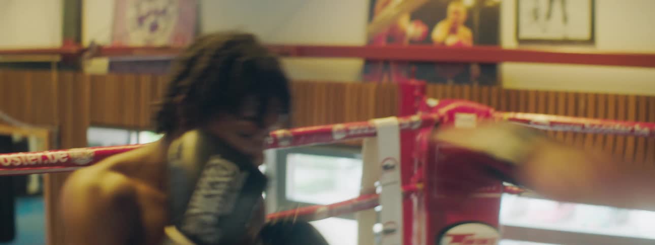 Two men spar in boxing ring in gym