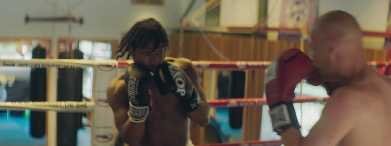 Two men box each other in a boxing ring
