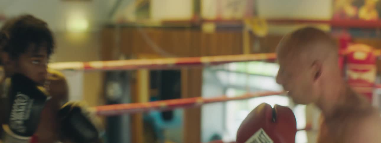 A woman trains at boxing with a sparring partner in a boxing ring