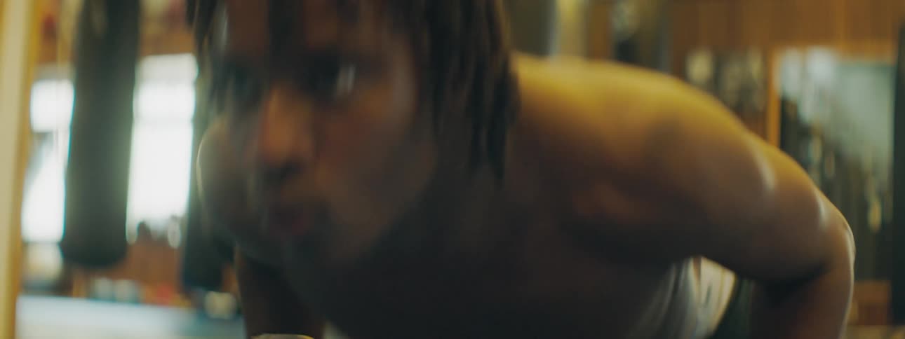 Man with braids does push ups in the gym