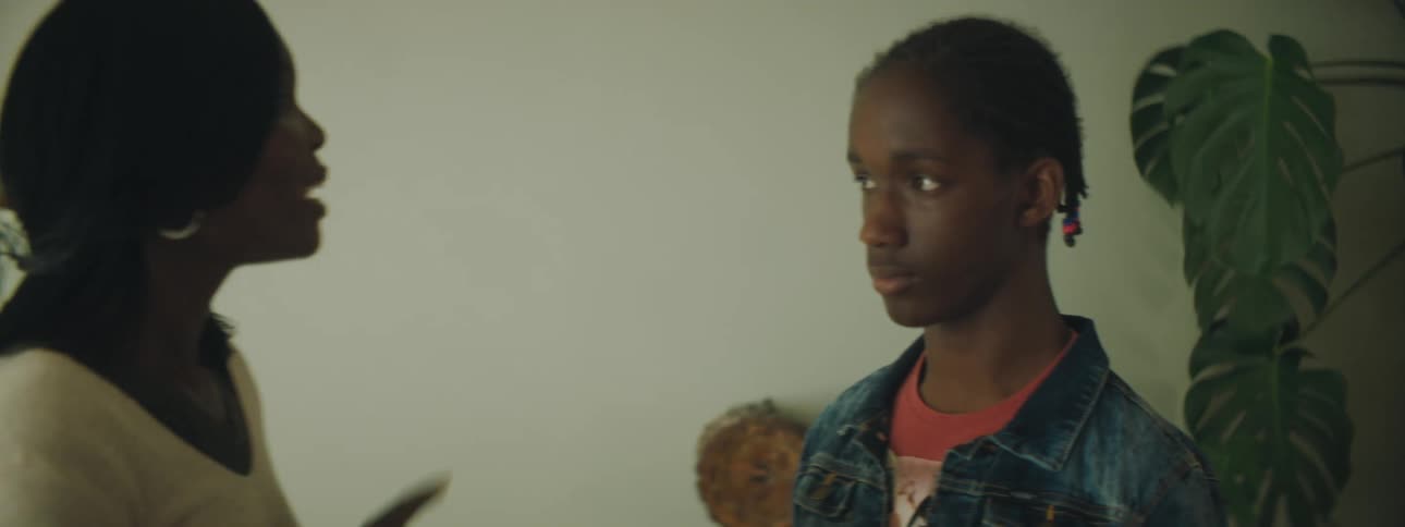 Mother yelling at her son inside of a home while the son watches her speak