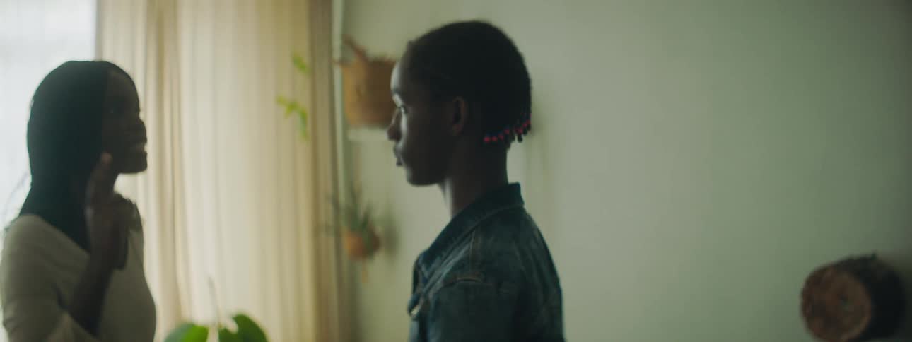 A teenage girl yells at a boy in her home