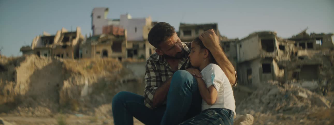 A man embraces a young girl in his arms