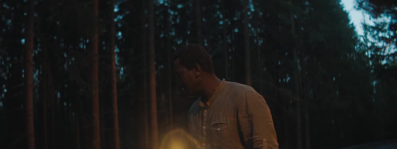 A man is walking outdoors in the woods