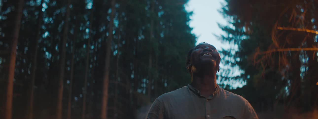 A man is walking outdoors in the woods