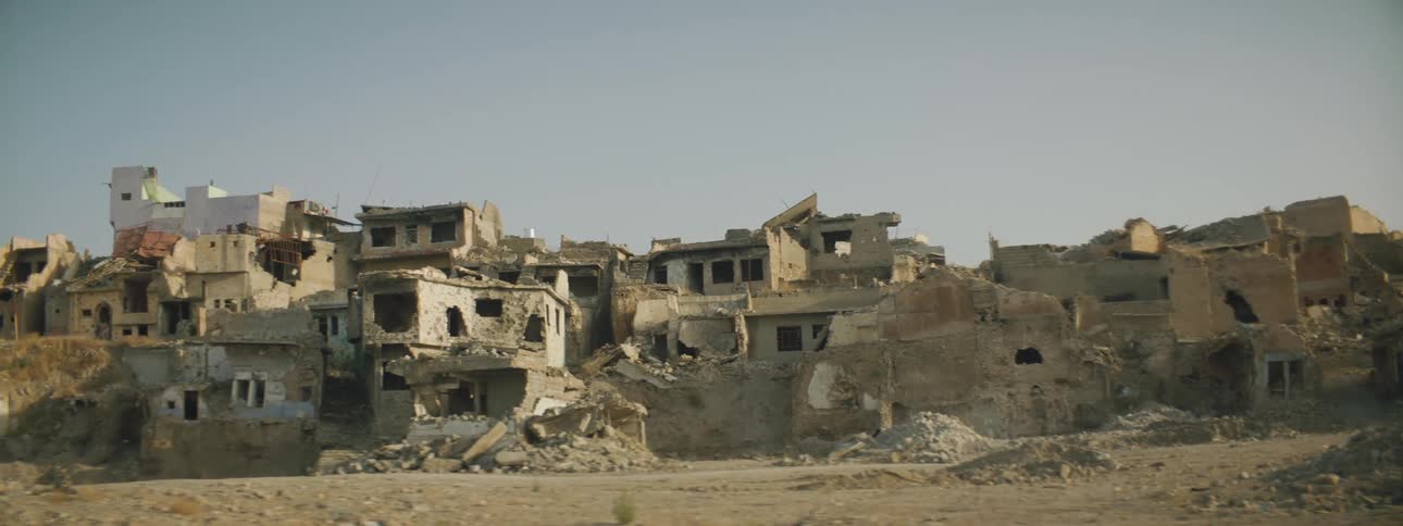 Rubble surrounds damaged homes sitting on hill