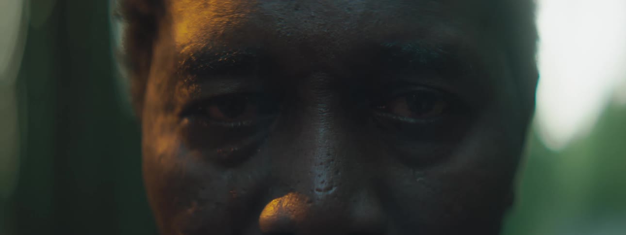Man standing with eyes closed outdoors opens eyes