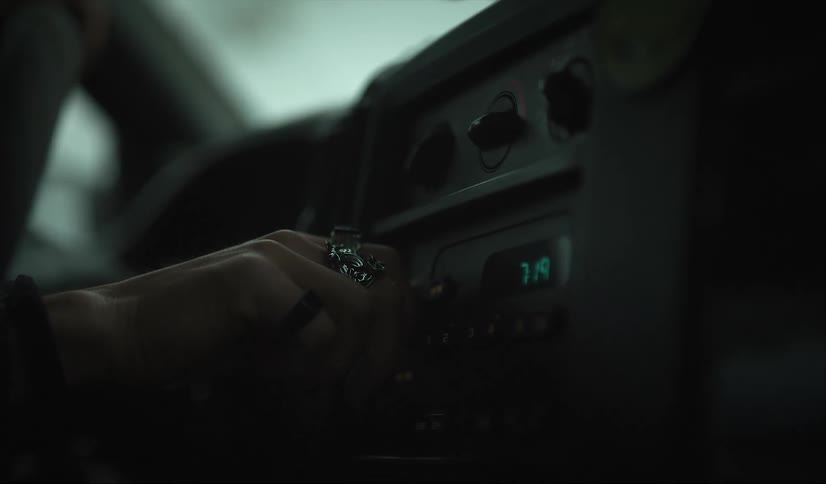 A person in a car turns a knob on the dashboard