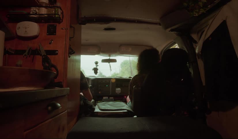 A man and woman are in a motorhome driving down the road
