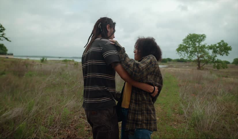 Young couple dance slowly on a grassland plain near a lake