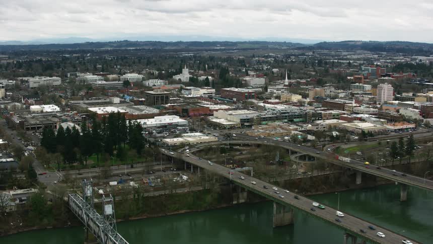 Aerial view of cars driving on bridges over a river near a small town