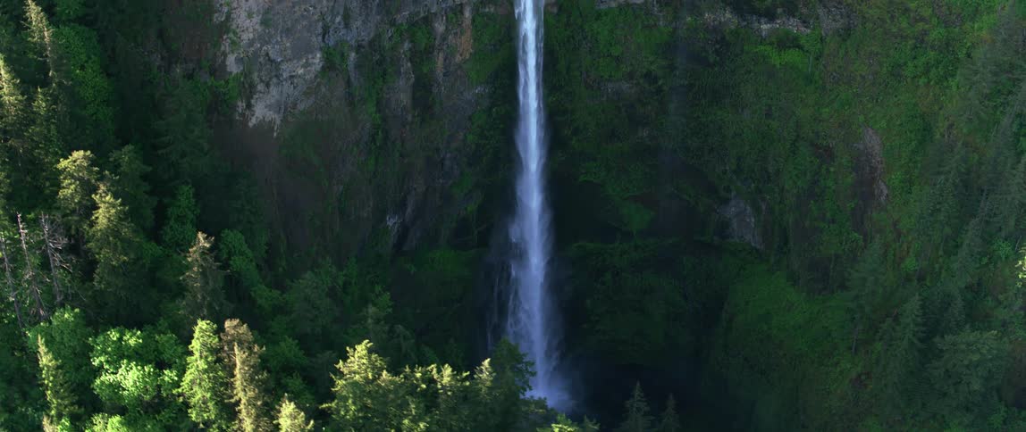 A waterfall off a sheer cliff with water splashing into the basin
