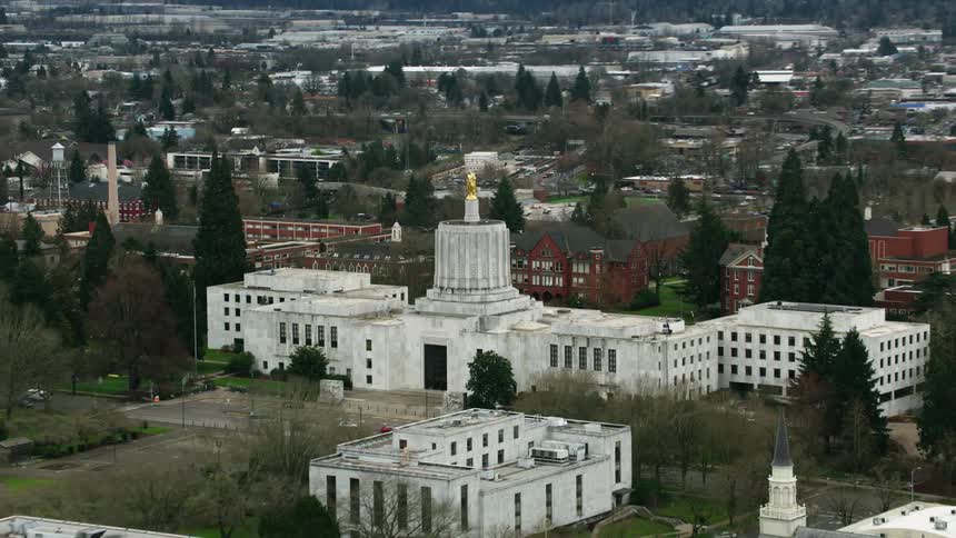 Aerial view of a golden statue atop a government building on a small town
