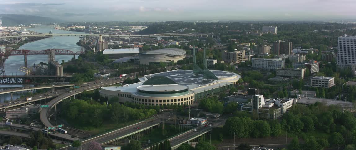 Aerial view of a stadium or convention center near a river on a small city
