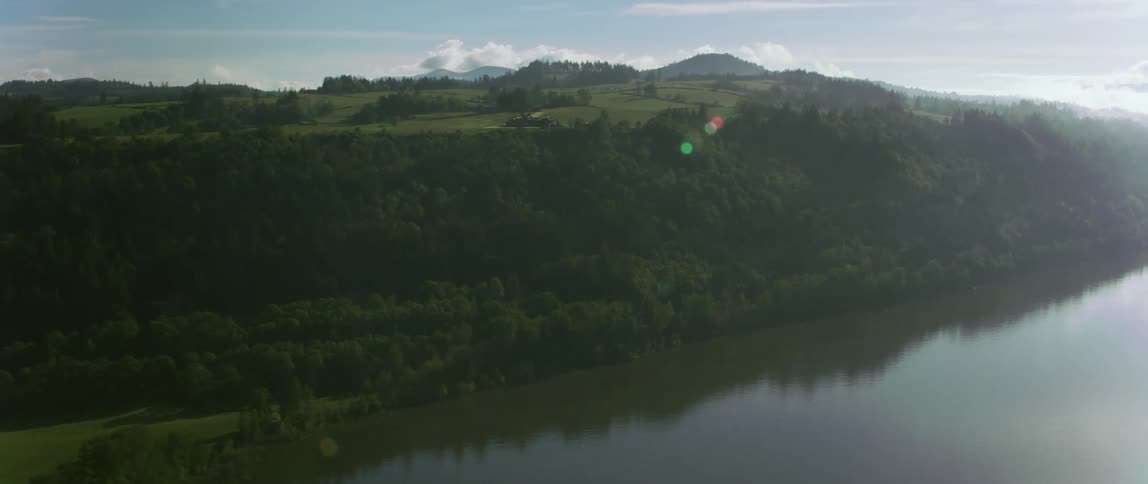 A lake is reflecting the mountains and trees around it