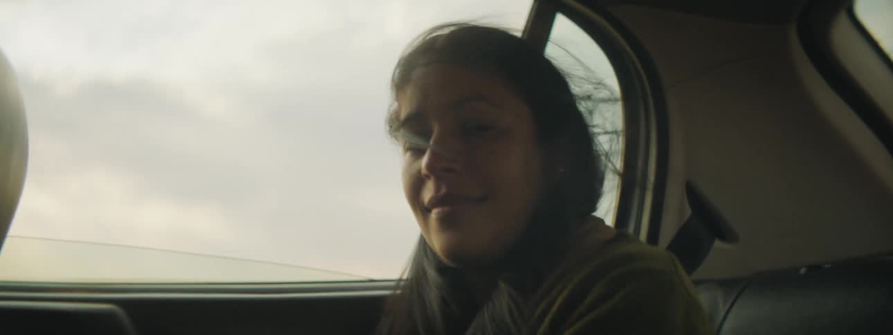 A girl is riding in the back seat