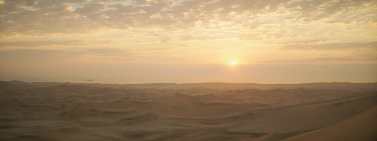 The sun setting over a sandy desert landscape in nature