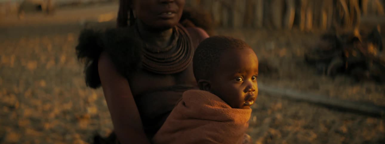 A woman sits with her baby outside