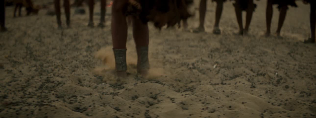 A person dancing on sand raising dust