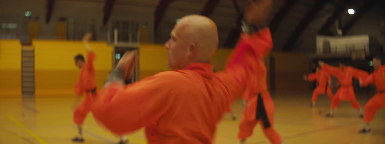 A group of people doing martial arts in a stadium