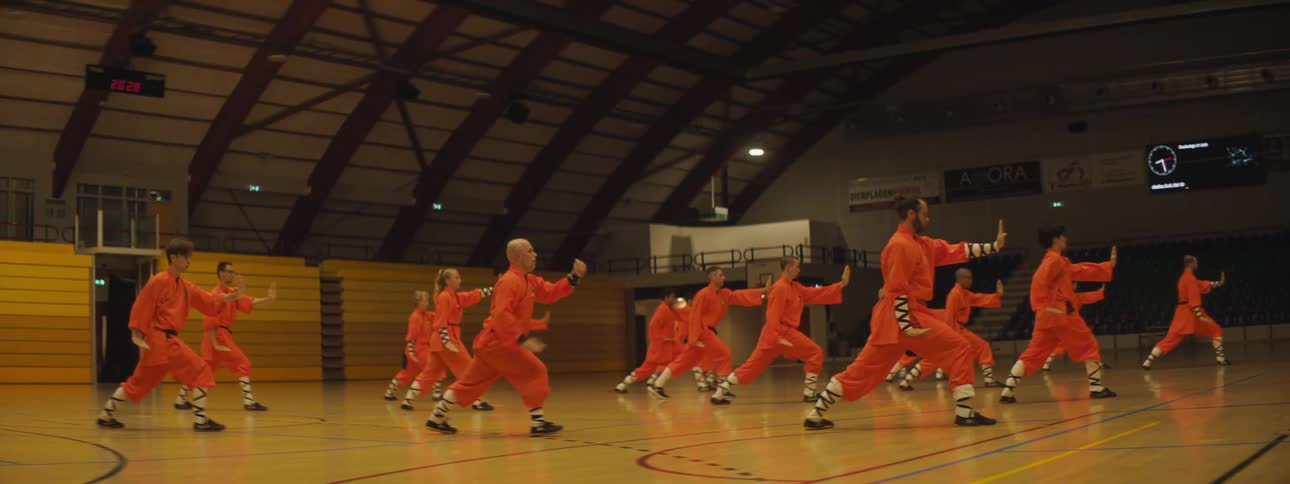 A group of people performing martial arts in a gymnasium