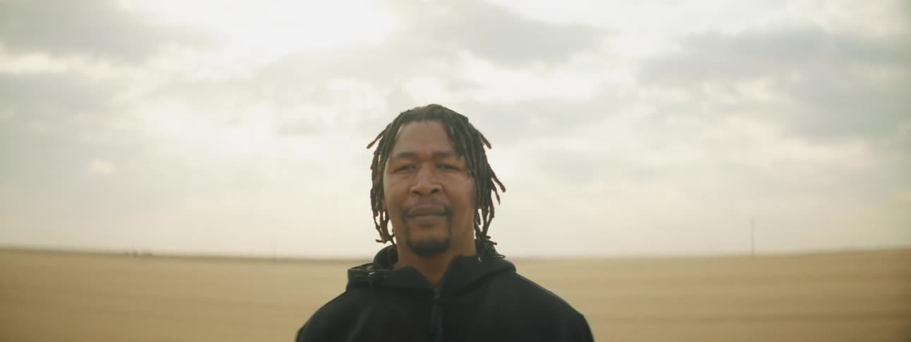 A man is standing outdoors in a rural area