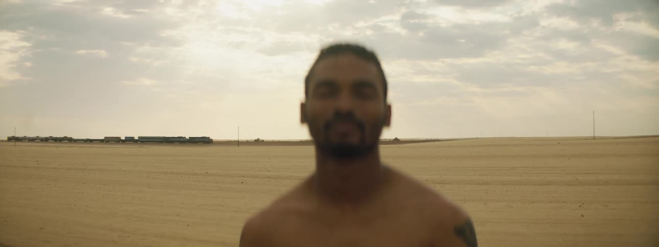 A man is standing outdoors in a rural area