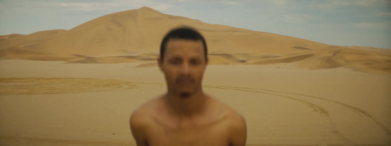 A man is standing outdoors in a desert