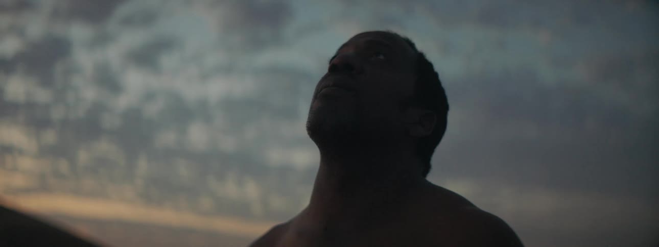 A man is standing outdoors at dusk