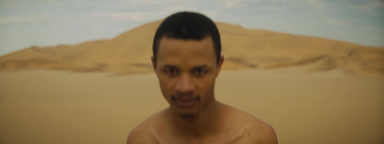 A man is standing outdoors in a desert
