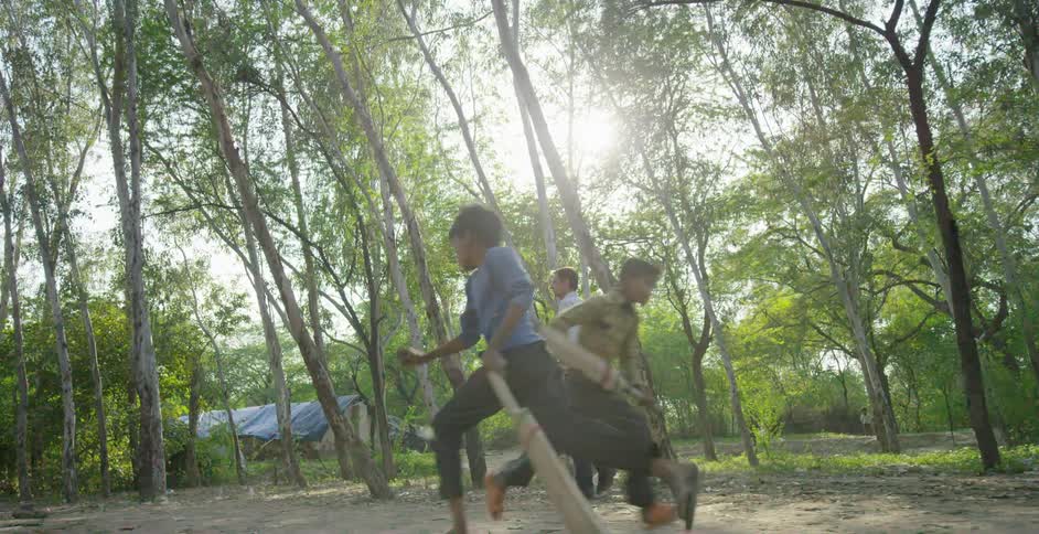 Kids play as a man walks past with a camera