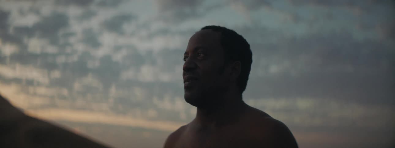 A man is standing outdoors at dusk