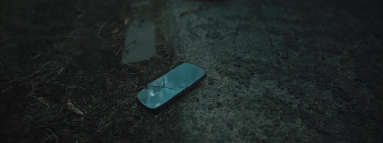 A cracked phone is on the ground