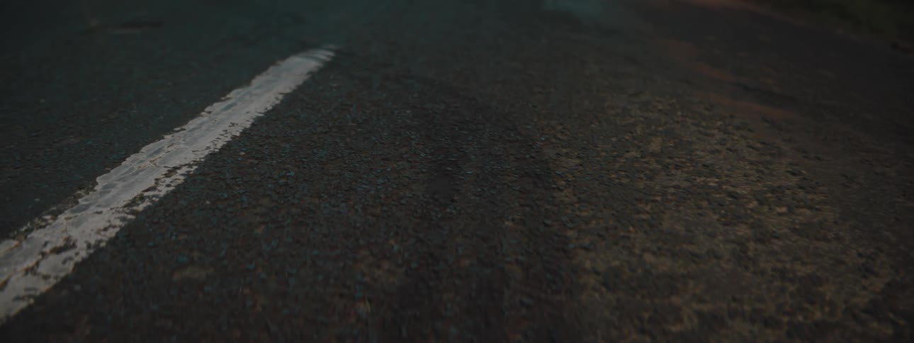 Skid marks on wet road lead to smoking car on shoulder with lights on