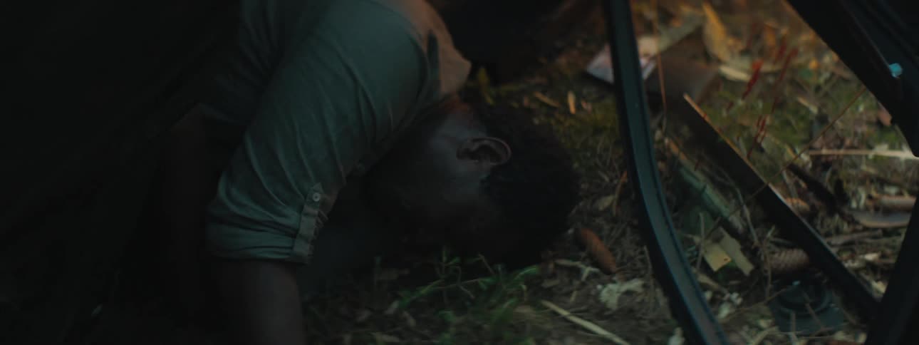 Man lies half in and half out of wrecked car lying on its side with blood on door window