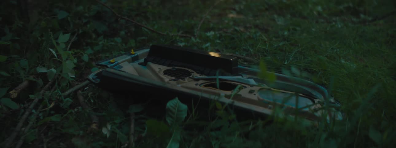 Broken panel lays on ground in field