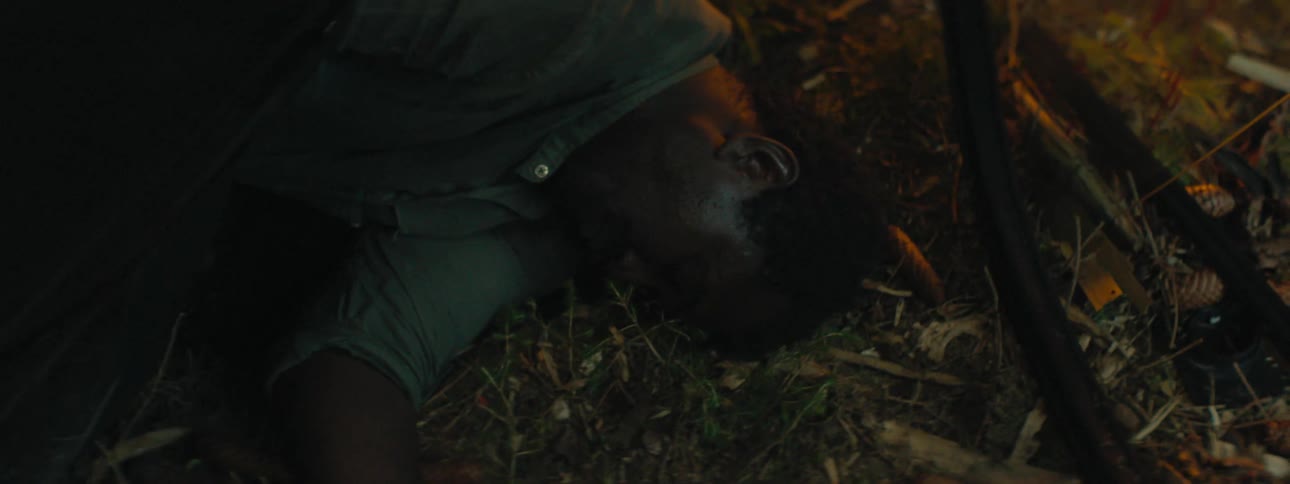 A man is laying in the grass at night