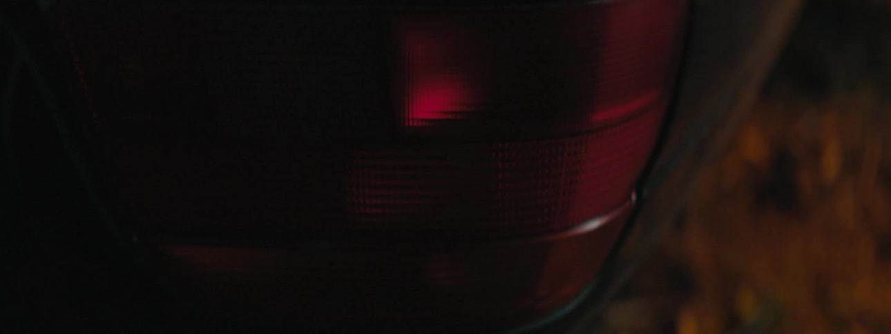 Flashing red tail lights on a car in the dark