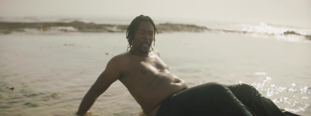 Man stops attempting resuscitation efforts and collapse back into water on beach