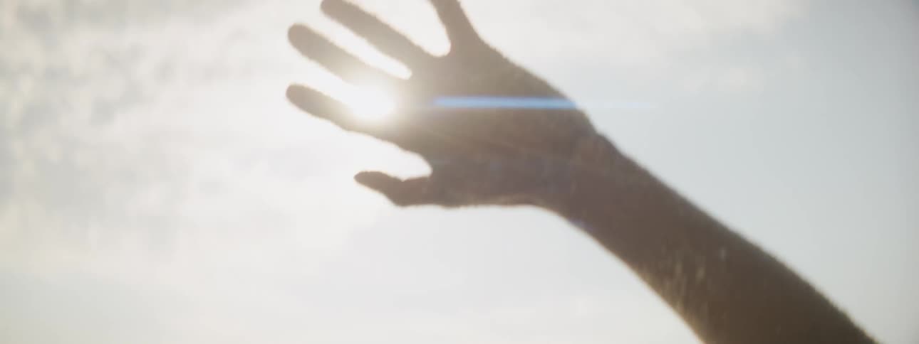 A man holds his hand up towards the sky