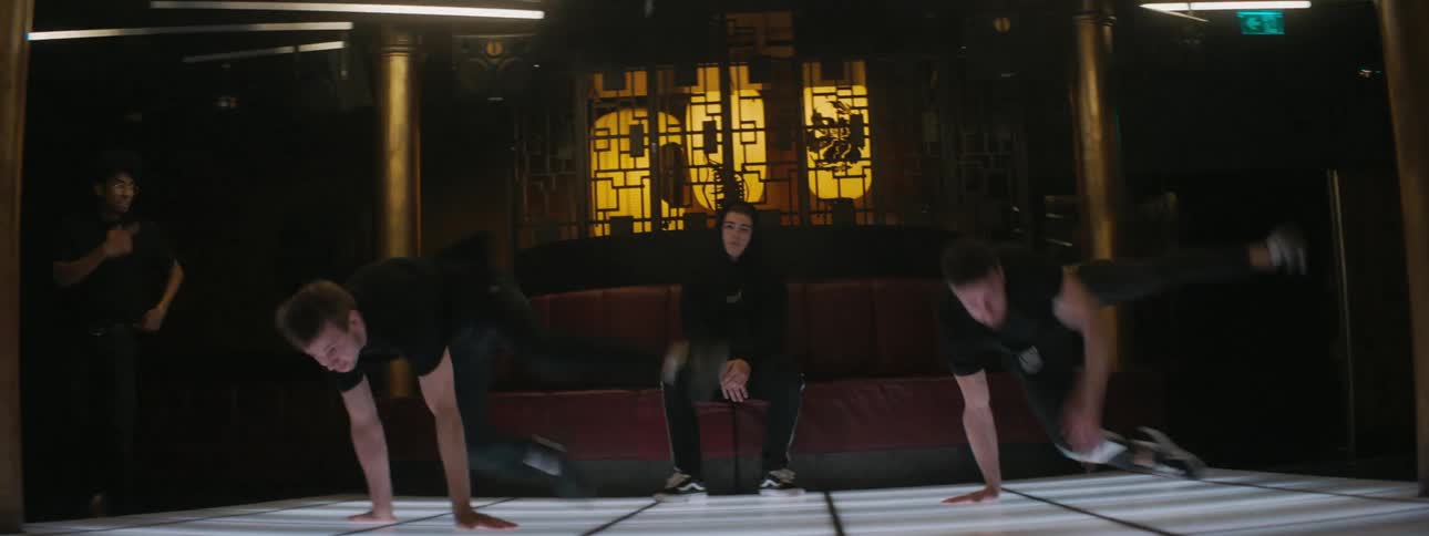 A troupe of break dancers perform simultaneous dance moves