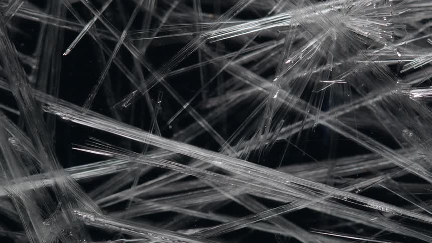 Rods of ice growing and expanding creating a design against black