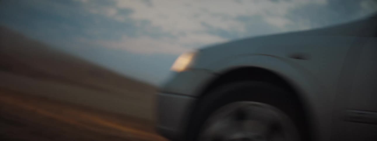 A car is driving in a rural area