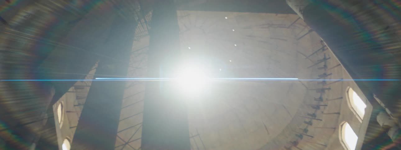 Sunlight shines through a small hole in the top of a dome causing a lens flare on the camera