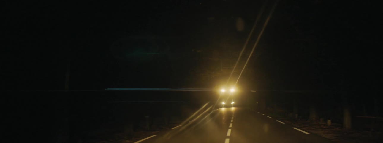 Semi truck with headlights on passes by at night